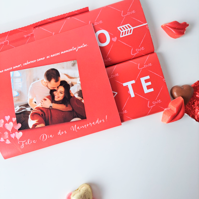 Cartão vermelho com foto de casal e chocolates vermelhos em forma de lábios e coração