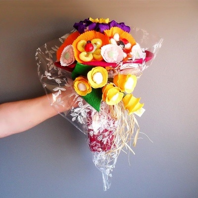 Buquê colorido de flores artificiais embalado em plástico transparent
