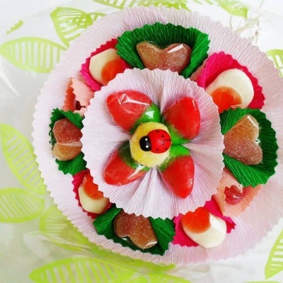 Arranjo de gomas coloridas em forminhas de papel com figura central de joaninha