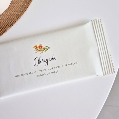 Embalagem branca com texto de agradecimento e desenho floral