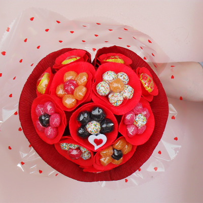 Bouquet de doces coloridos e chocolates em forma de coração, embalado com papel celofane com corações vermelhos