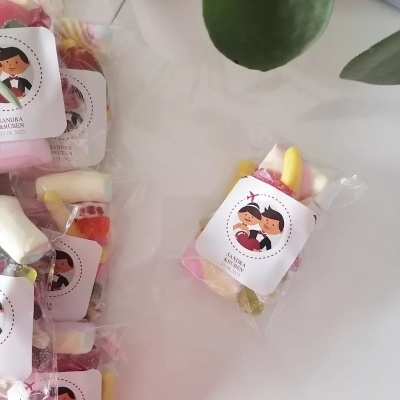 Saquinhos de Gomas do Casamento Sandra & Rúben Pacotes pequenos de doces em saquinhos transparentes com etiquetas brancas ilustradas sobre mesa branca