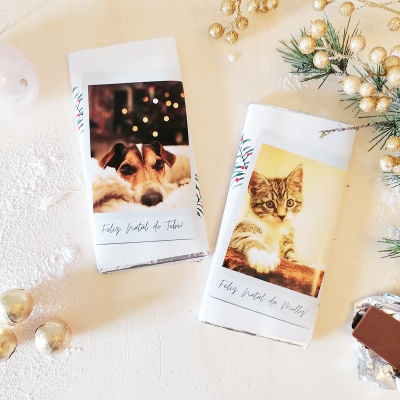 Barras de chocolate com embrulho natalício com fotos de um cão e um gato e texto de Feliz Natal