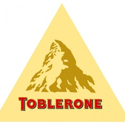 Logotipo da Toblerone em forma de triângulo amarelo com texto vermelho e montanha estilizada