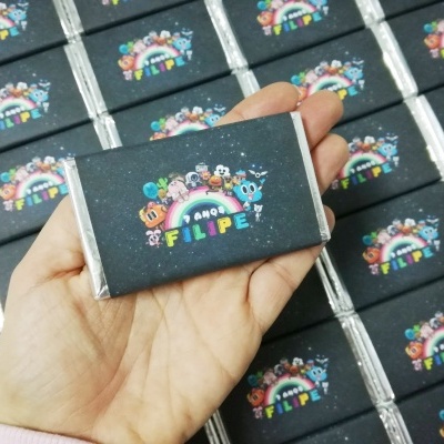 Caixa pequena retangular com design colorido e texto 'FILIPE 4 ANOS'