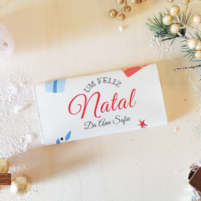 Barra de chocolate com embalagem natalícia branca e decorada com texto e desenhos coloridos