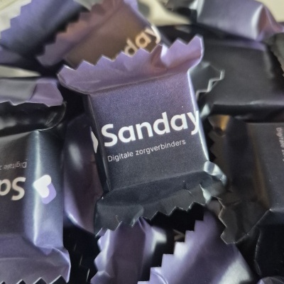 Doces embalados em papel roxo escuro com texto branco Sanday