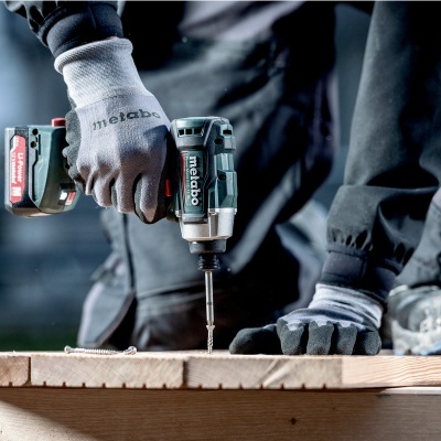 Parafusadeira elétrica Metabo numa superfície de madeira