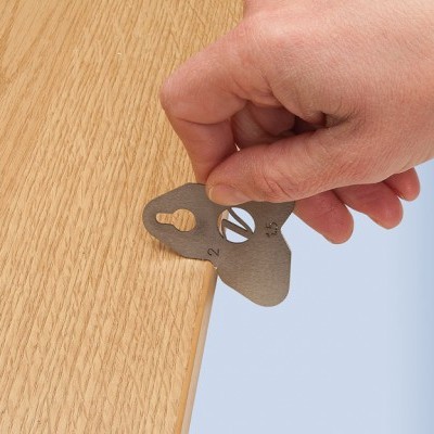 Chave metálica prateada para pendurar quadro em madeira