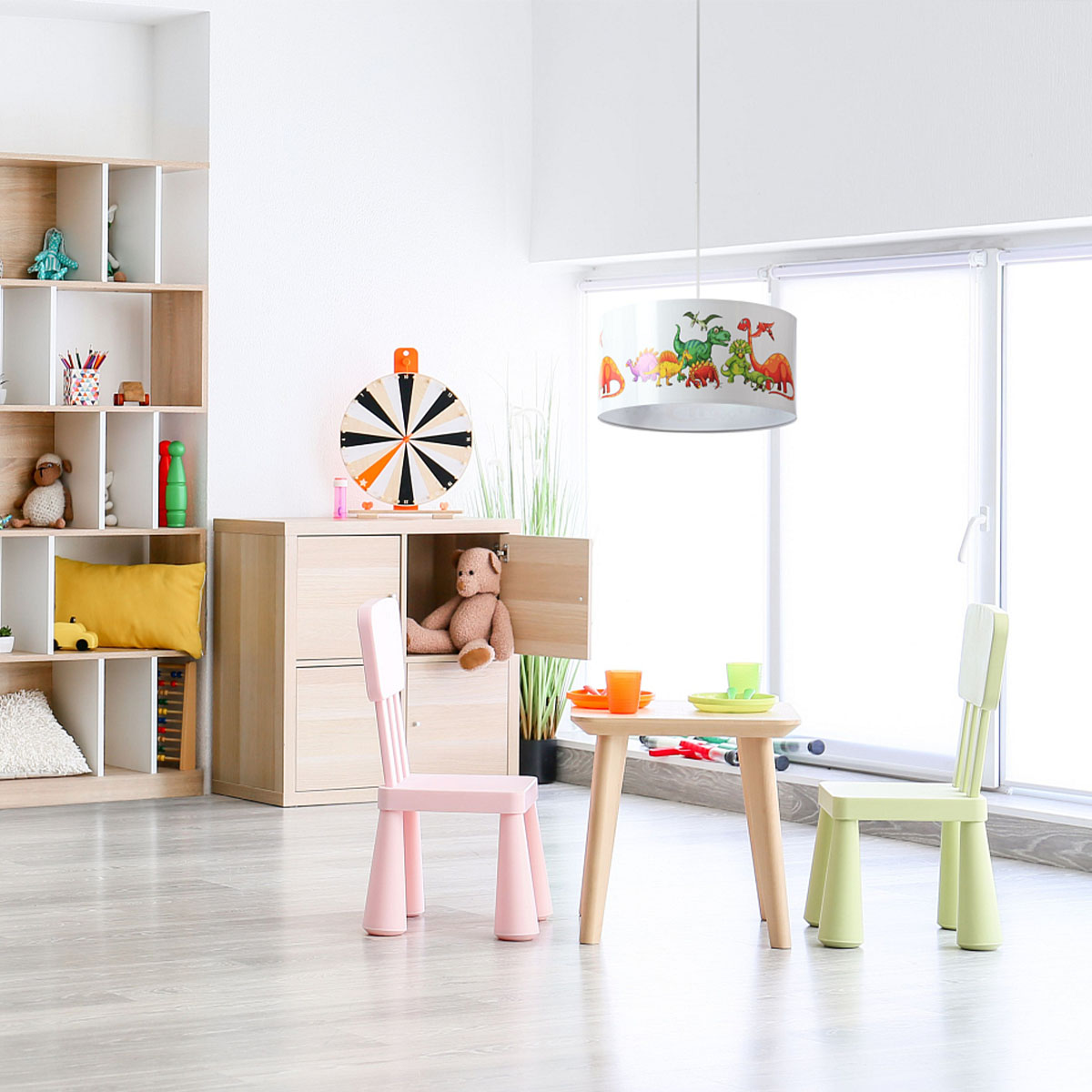 Candeeiro Suspenso Pequenos DINOSSAUROS Quarto infantil com móveis de madeira clara, cadeiras coloridas, candeeiro com dinossauros e brinquedos organizados.