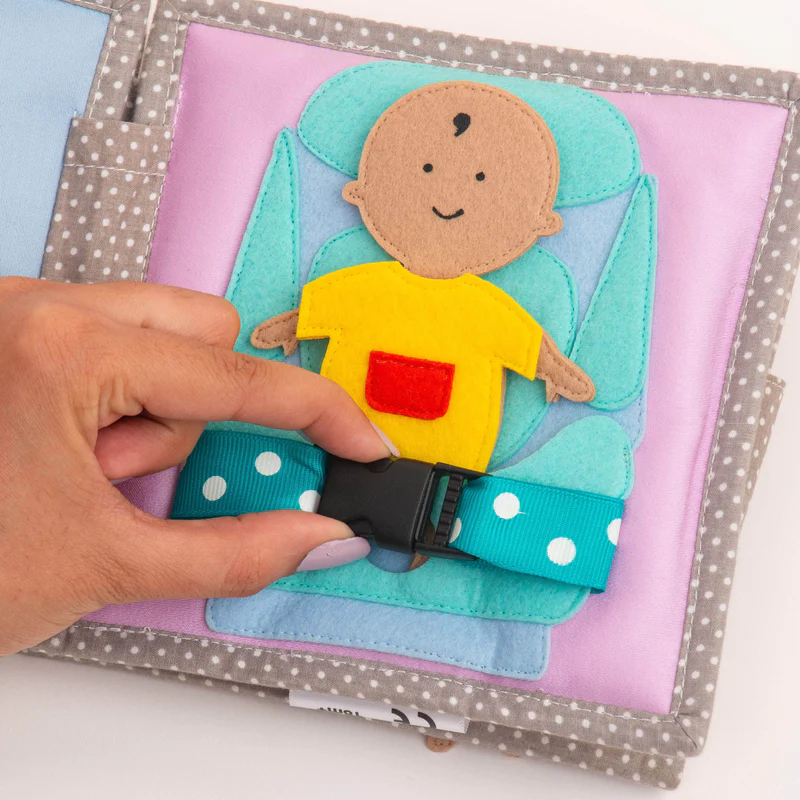 Bebé Feliz – MINI Livro Sensorial de 6 Páginas Livro de tecido com ilustração de bebé e cinto azul com pontos brancos