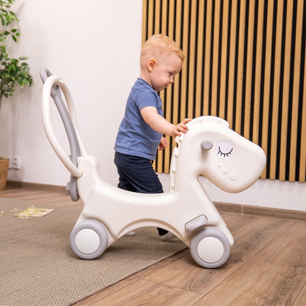Cavalo de Balanço Infantil 2 em 1 Criança a usar andador infantil cavalo branco com rodas cinzentas em interior