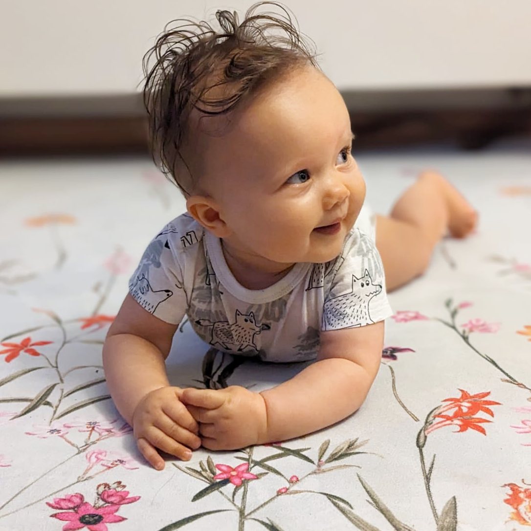 Tapete Redondo ECO de Bebé Jardim de Flores Bebé deitado em colchão com padrão floral colorido