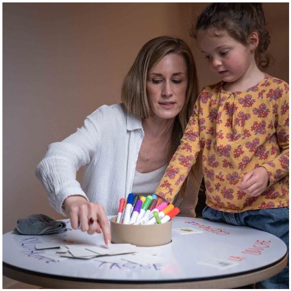 Base de Mesa para Desenhar Dupla Face Mesa redonda branca com marcadores coloridos e cartões educativos, mulher e menina interagindo