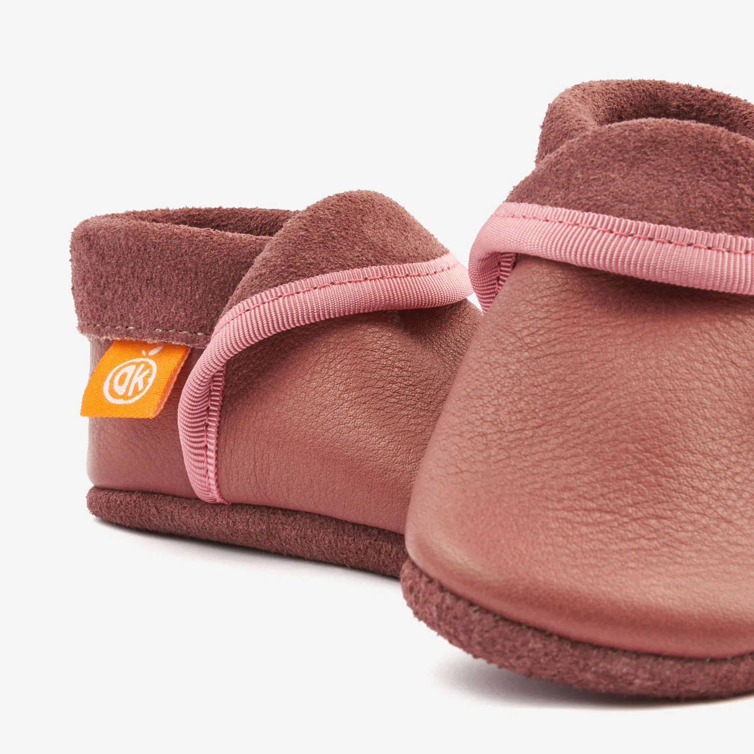 Sapatinho Infantil Clássico Rosa Sapatilhas infantis rosa com detalhe em camurça e etiqueta laranja.
