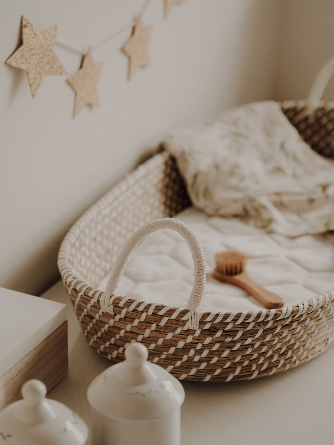 Cesto de Moisés Fraldário em Algas Marinhas Naturais Berço em vime com colchão branco e decoração com estrelas de cortiça na parede