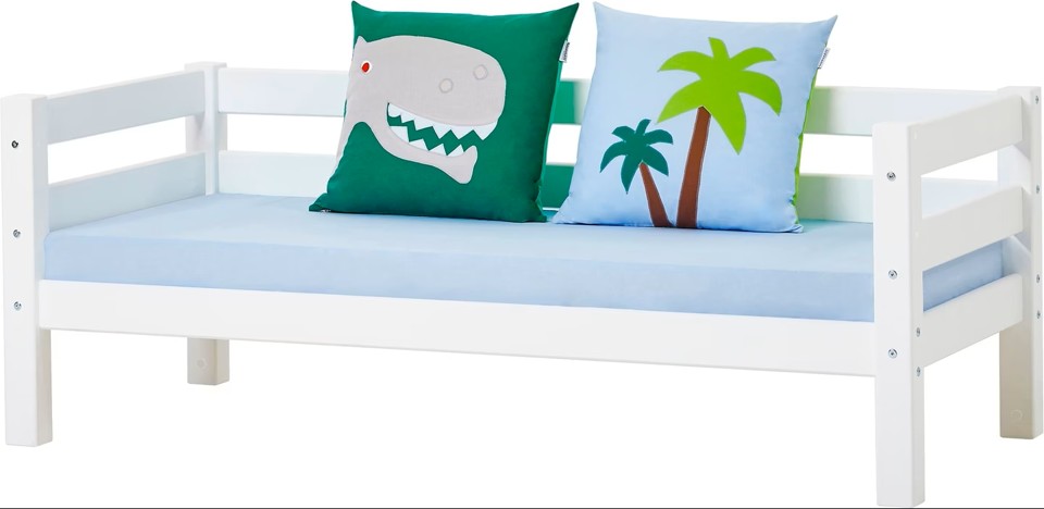 Conjunto de Almofadas Dino Cama infantil branca com colchão azul claro e duas almofadas coloridas com desenhos
