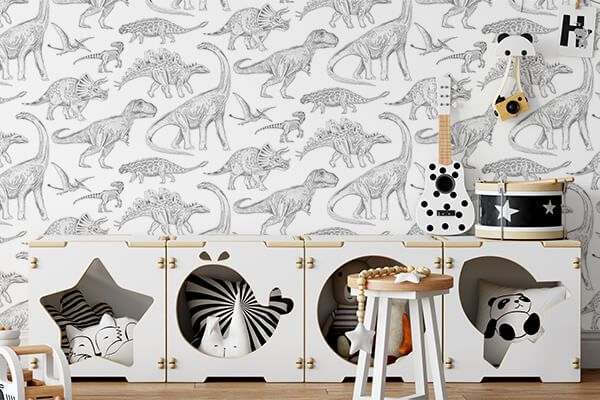 Papel de Parede Dinossauros BRANCO Divisão infantil com papel de parede de dinossauros em tons cinza, móvel branco com portas decorativas, guitarra e tambor em cima.