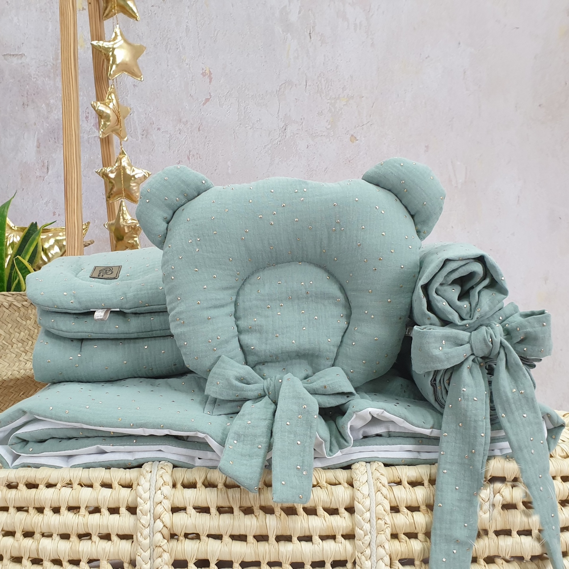 Cesta Moisés de Vime Branco SARA com Roupa de Cama Acessórios de bebé verdes com pontos dourados num cesto de verga