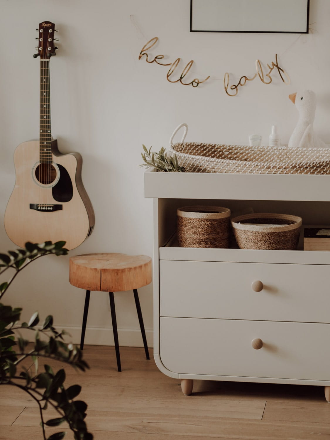 Cesto de Moisés Fraldário em Algas Marinhas Naturais Quarto com guitarra acústica, banco de madeira, cómoda branca com cestos, berço de vime e móbile HELLO BABY