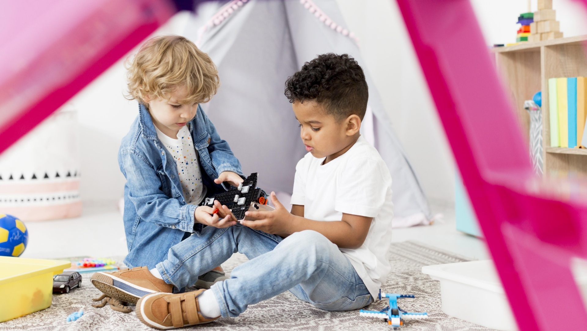 Duas crianças a brincar com blocos de construção num quarto infantil