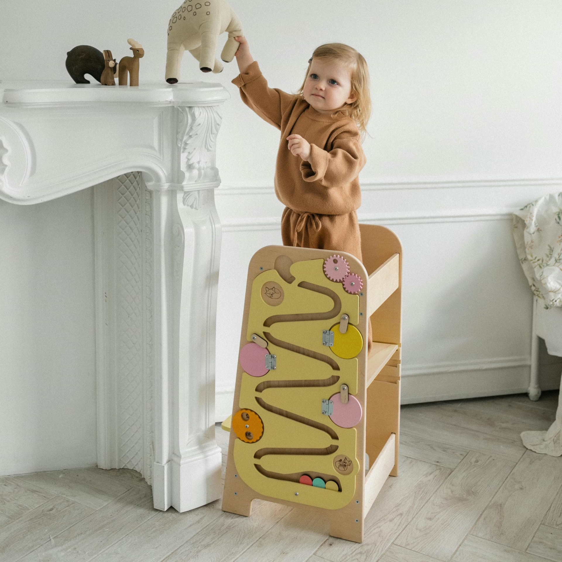 Torre de Aprendizagem Multifuncional 5 em 1 Criança a brincar com peluche e cadeira de aprendizagem de madeira com labirinto de cores pastel