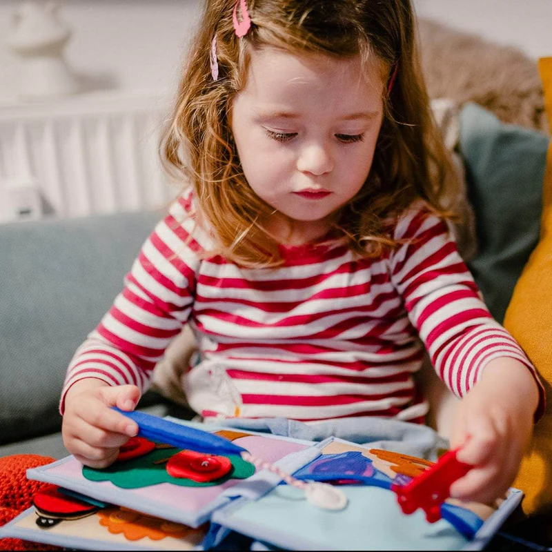 Arco Íris - Mini Livro Sensorial de 6 Páginas Criança a brincar com livro de tecido colorido