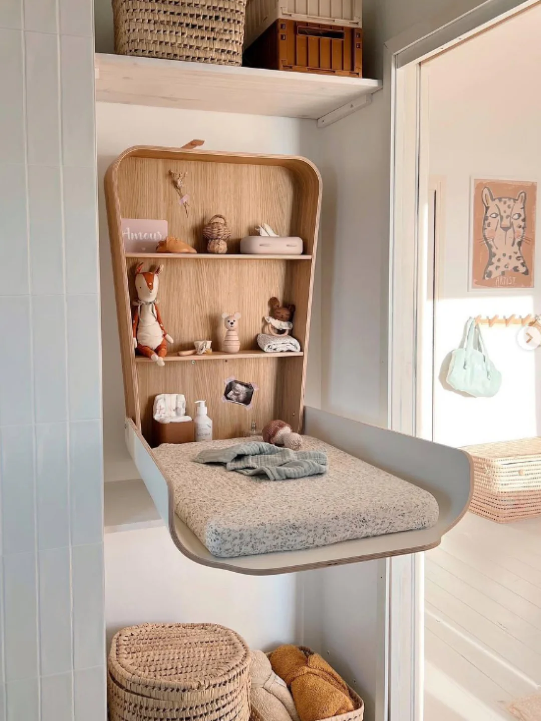 Trocador de Fraldas NOGA para Parede Muda fraldas dobrável branca com prateleiras em madeira clara e objetos decorativos