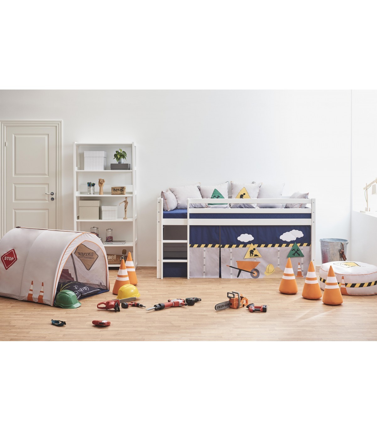 Túnel de Brincar - Construção Quarto infantil com cama branca e azul decorada com tema de construção e brinquedos relacionados.