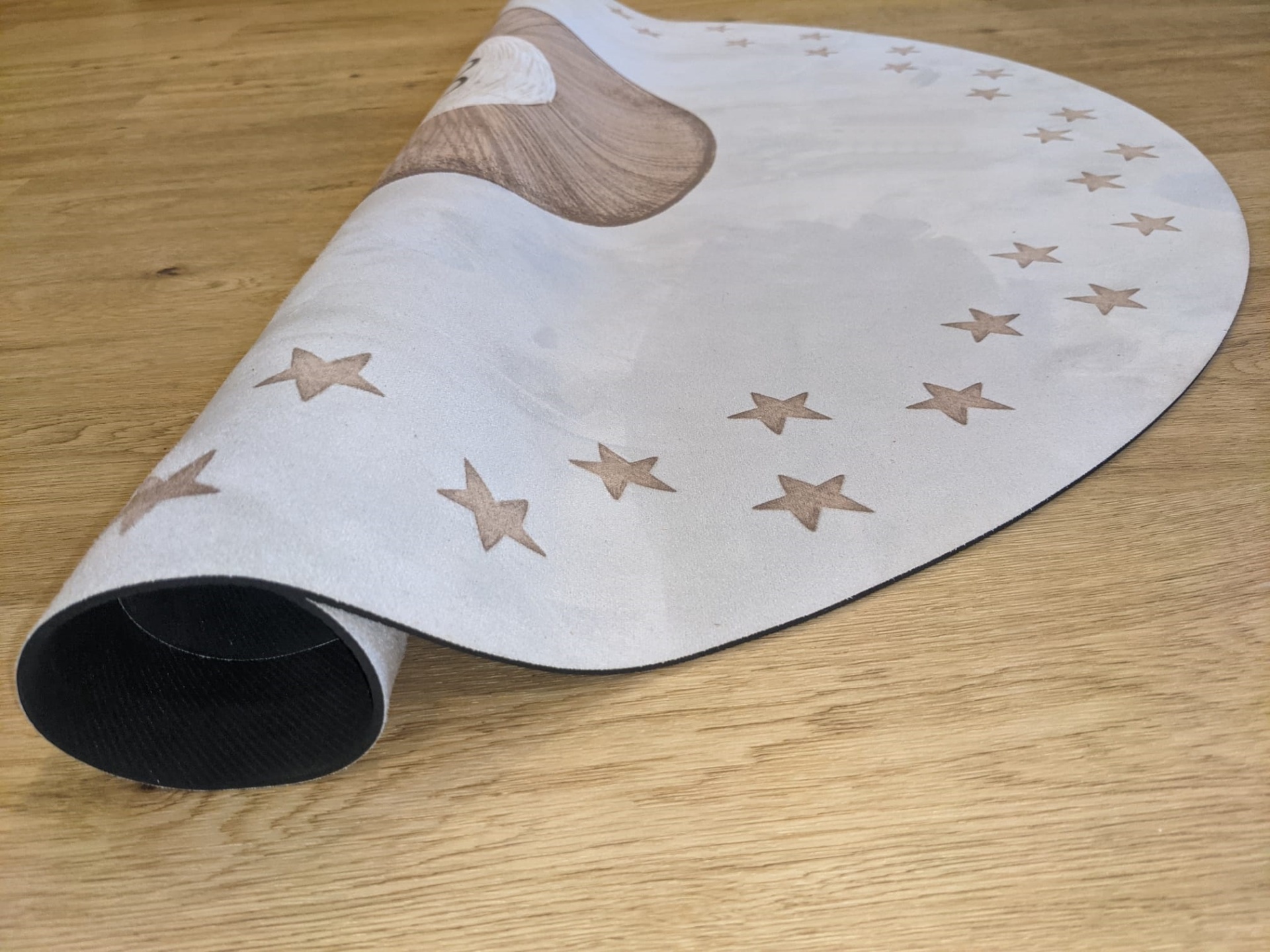Tapete Redondo Borracha Natural URSO TEDDY Tapete branco com estrelas bege sobre superfície de madeira clara