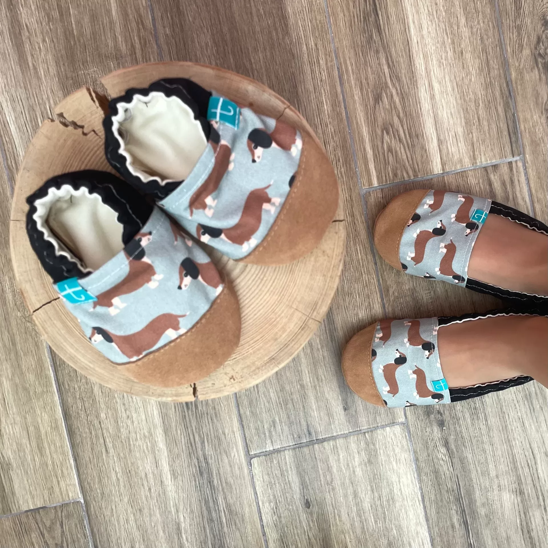 Sapatinhos de Criança em Couro Natural – Cachorro Salsicha Sapatos com padrão de cães dachshund em tecido azul claro e camurça castanha.