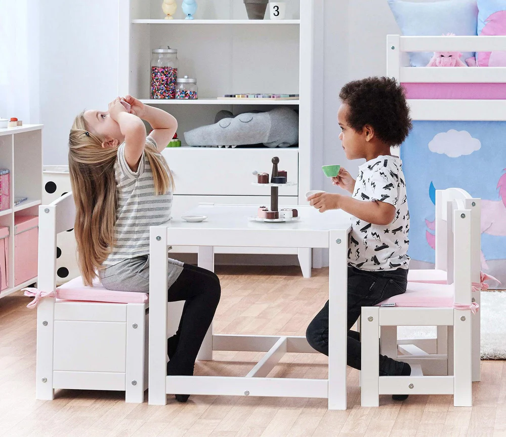Conjunto Infantil MATILDE – Mesa, Cadeiras e Banco com Arrumação Mesa e cadeiras infantis brancas com crianças brincando num quarto infantil