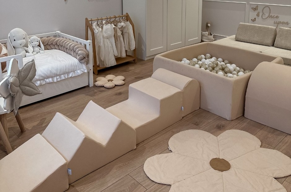 Quarto infantil com cama branca, brinquedos de pelúcia e piscina de bolas neutra