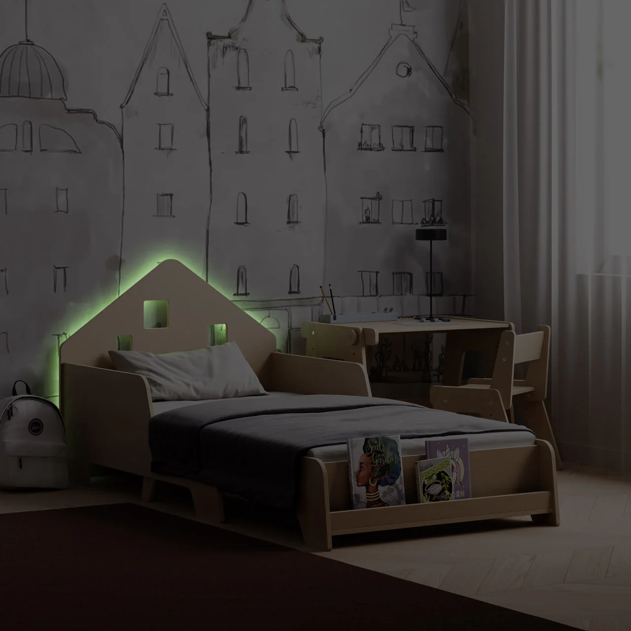 Cama Extensível em Forma de Casa com Iluminação LED Cama infantil de madeira clara com cabeceira em forma de casa iluminada em verde numa divisão com secretária e parede com desenho de edifícios.