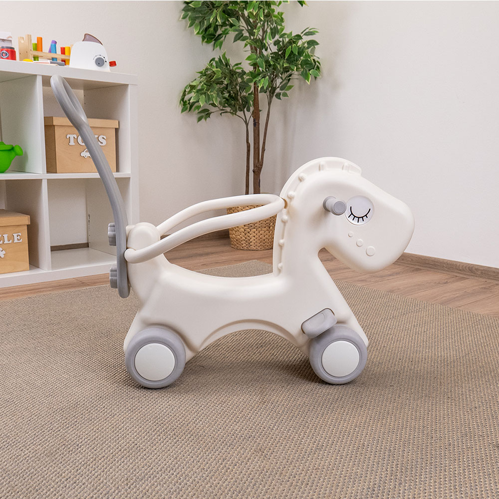 Cavalo de Balanço Infantil 2 em 1 Andarilho infantil branco em forma de cavalo com rodas cinza em tapete bege.