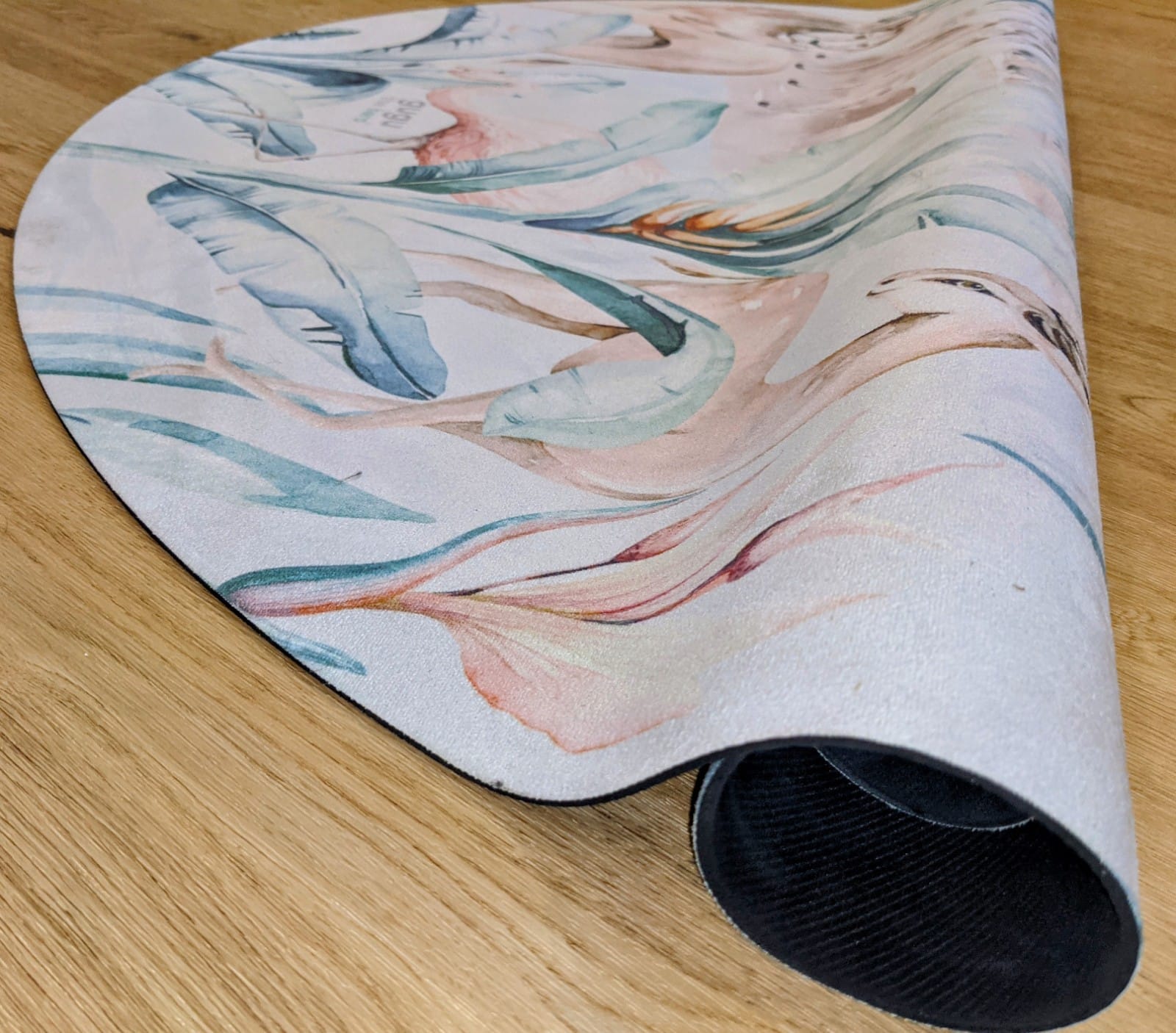 Tapete Redondo ECO Vida Animal Tapete redondo com padrão floral em tons pastel sobre chão de madeira