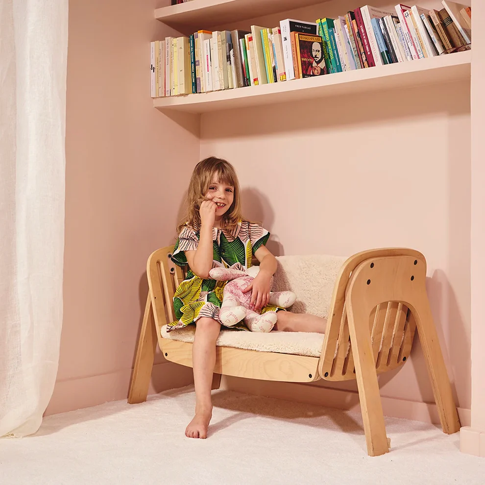 Almofadas para Berço/Banco KODO Criança num sofá infantil de madeira segurando ursinho de peluche