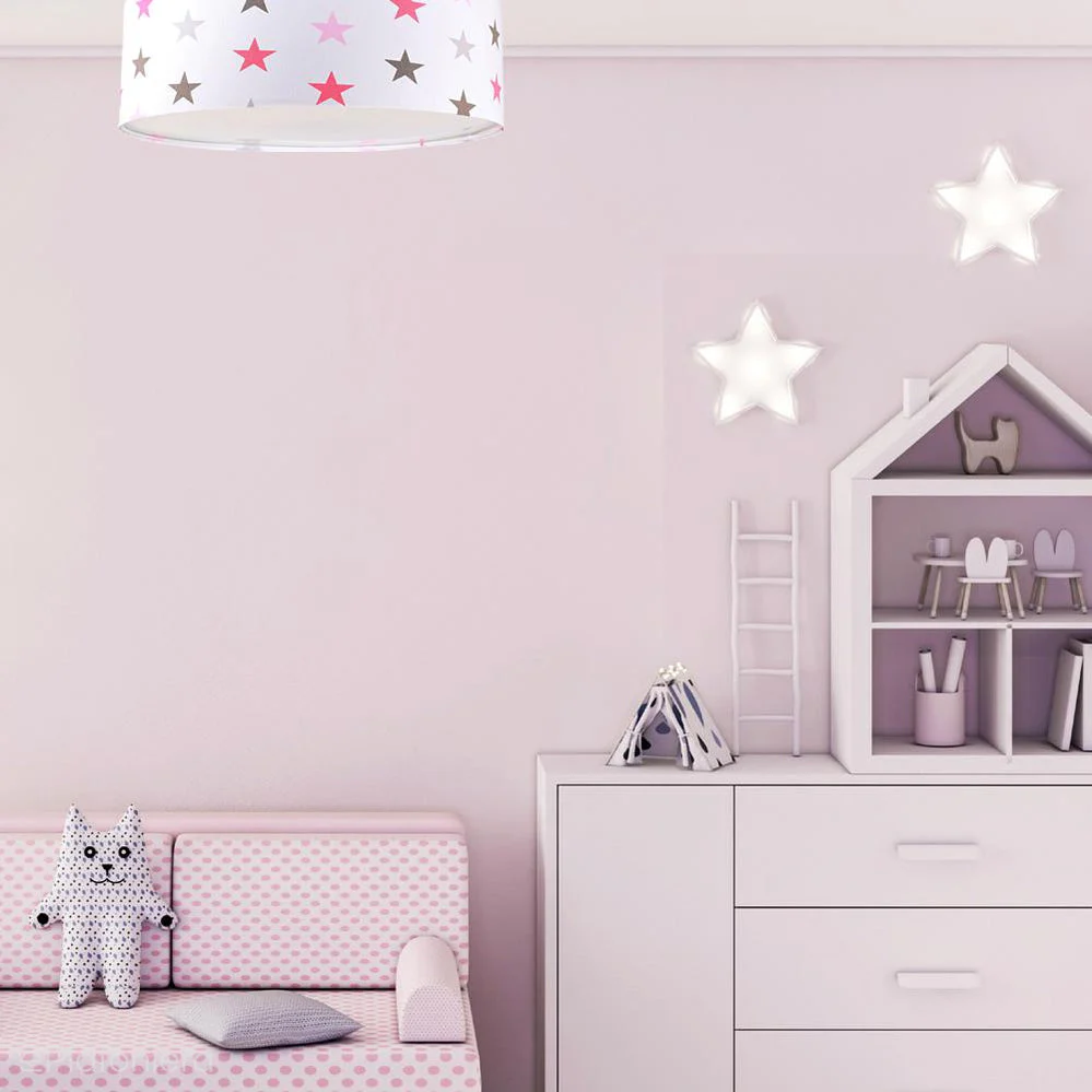 Candeeiro Plafon Estrelas CZARUS Quarto infantil rosa com candeeiro de teto de estrelas, sofá, peluche e mobiliário branco com prateleira em forma de casa