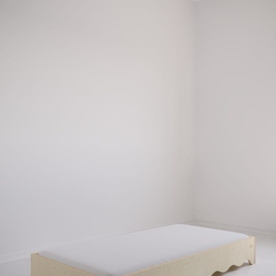 Cama baixa individual em madeira clara com colchão branco num quarto minimalista branco