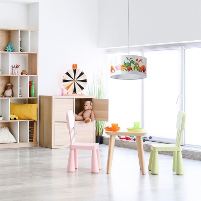 Quarto infantil com móveis de madeira clara, cadeiras coloridas, candeeiro com dinossauros e brinquedos organizados.