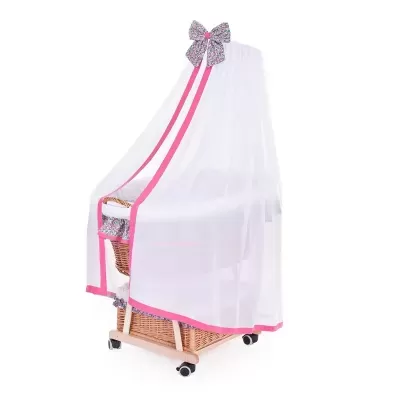 Berço de vime com mosquiteiro branco e bordas cor-de-rosa