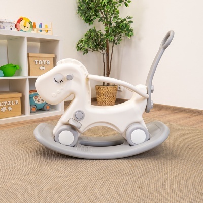 Brinquedo cavalo de balanço branco e cinza com alça num quarto infantil