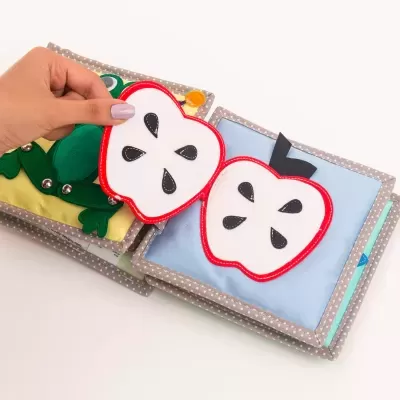 Livro de tecido infantil com páginas coloridas e maçãs de tecido