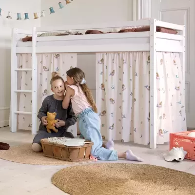 Cama elevatória branca com cortinas de sereias e crianças a brincar