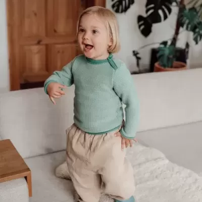 Criança vestindo roupa confortável e colorida num ambiente interior acolhedor