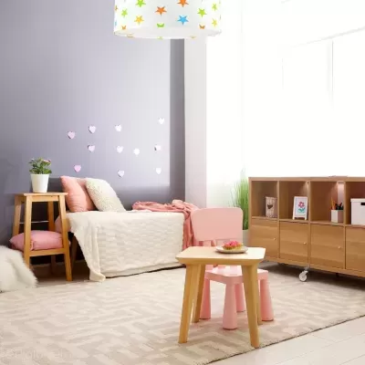 Quarto infantil com mobília em madeira clara, cama com roupa de cama clara e decoração colorida