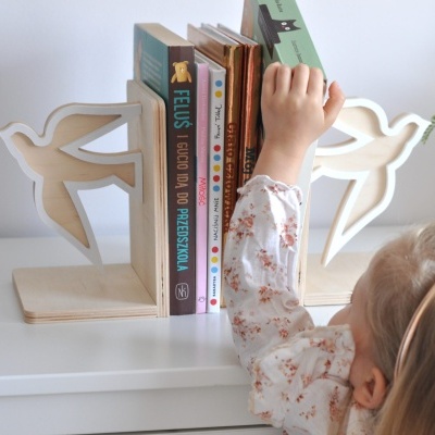 Organizador de livros de madeira com design de pássaros e vários livros, criança a pegar num livro.