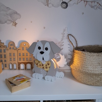 Candeeiro de cão cinzento e branco com bandana, cesta de palha e decoração de madeira em bancada branca