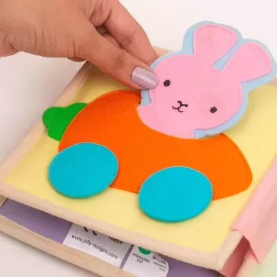 Livro macio infantil com figura de coelho cor-de-rosa e corpo em tecido laranja e azul