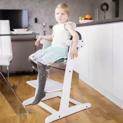 Cadeira alta ajustável branca com assento cinza para criança numa cozinha